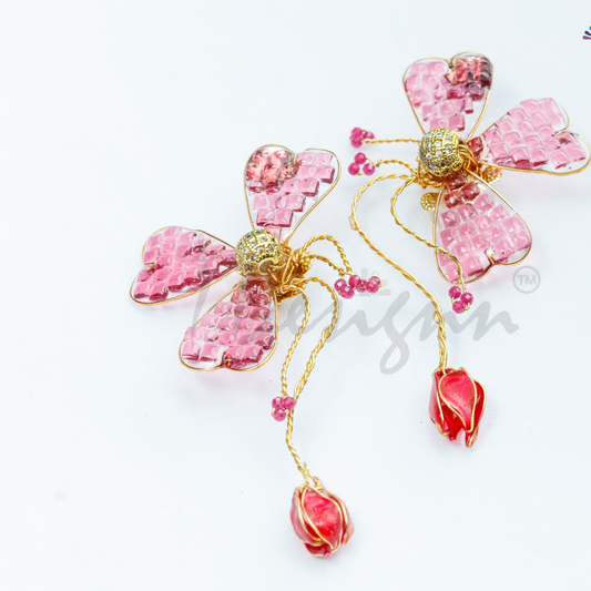 Pink floral earrings with gold accents on a white background