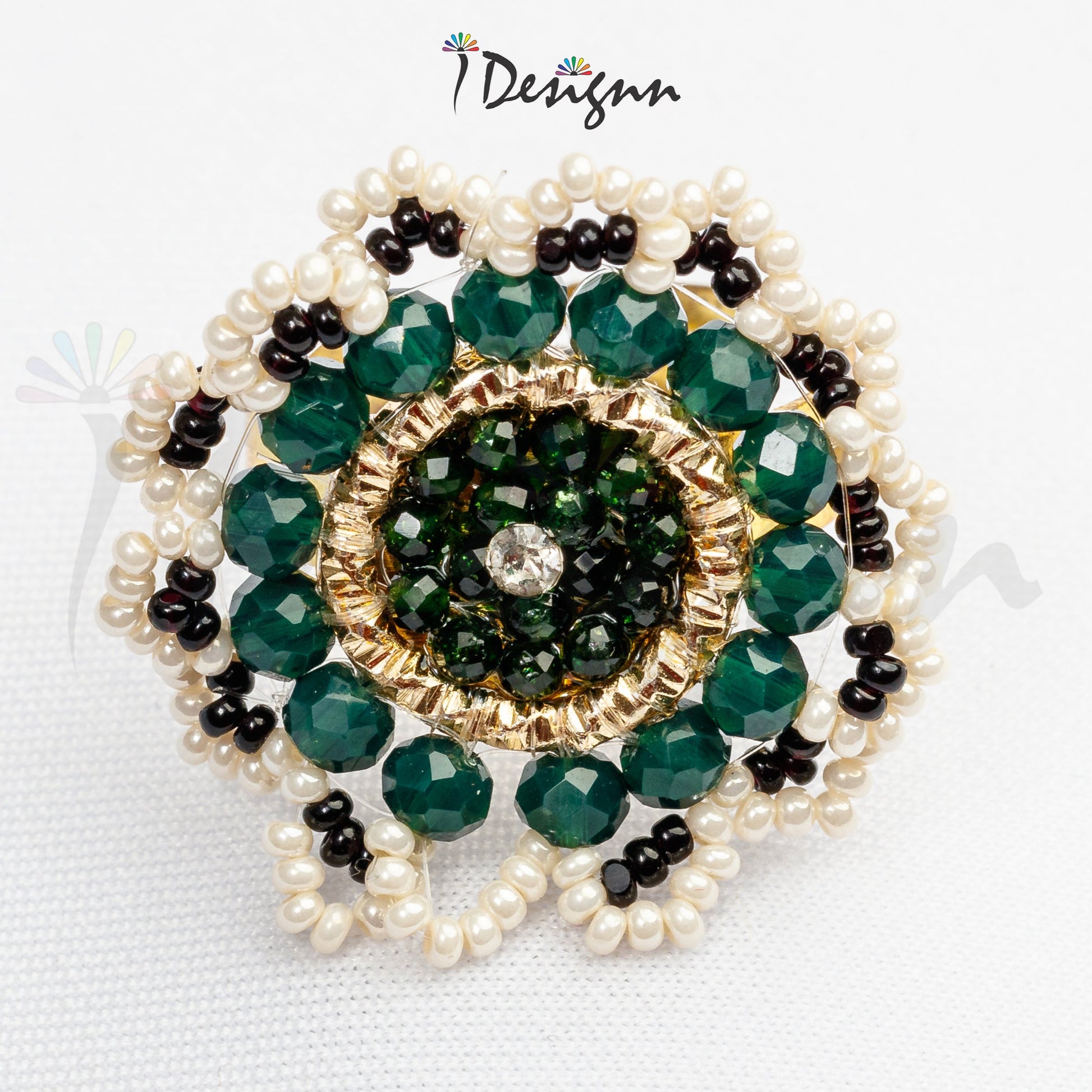 Jewelry piece with green beads and pearls on a white background