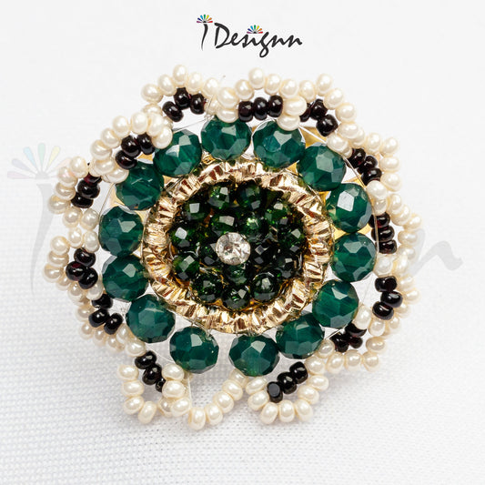 Jewelry piece with green beads and pearls on a white background