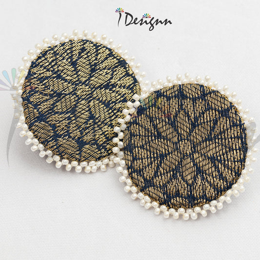 Pair of round earrings with black and gold pattern and pearl accents on a white background.