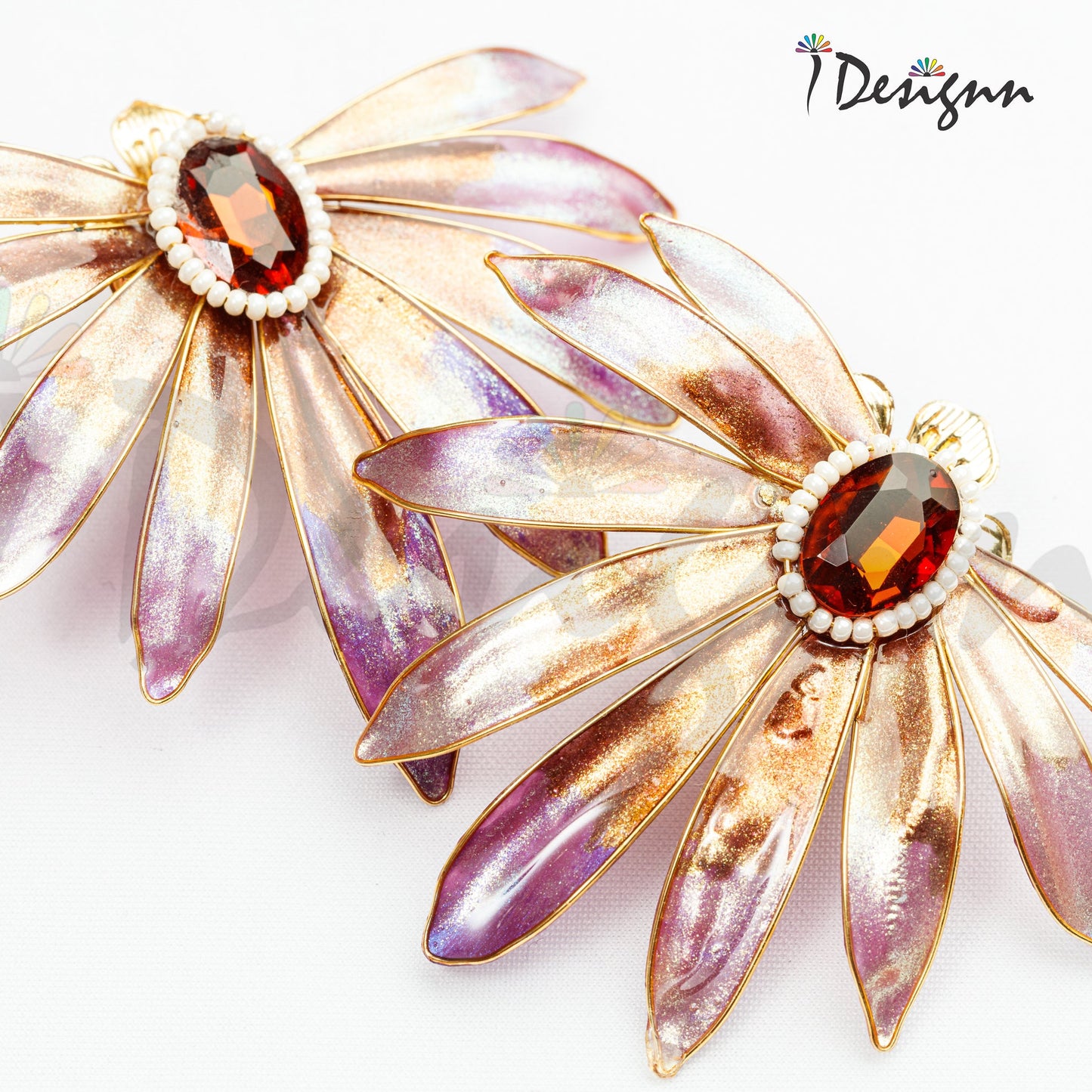 Pair of floral earrings with gemstones on a white background